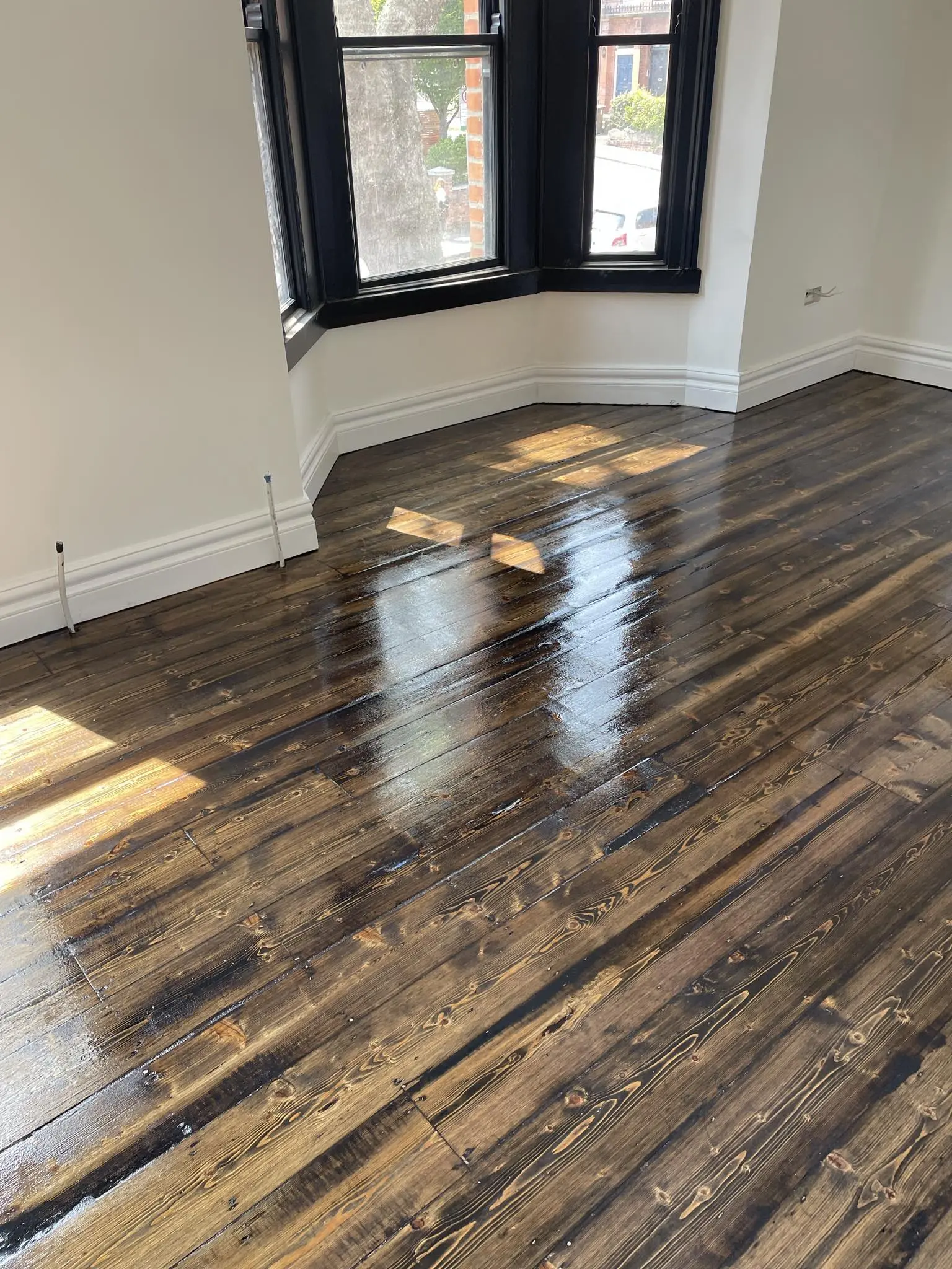 A wooden floor from a house perfectly sanded and stained with a nice coat.