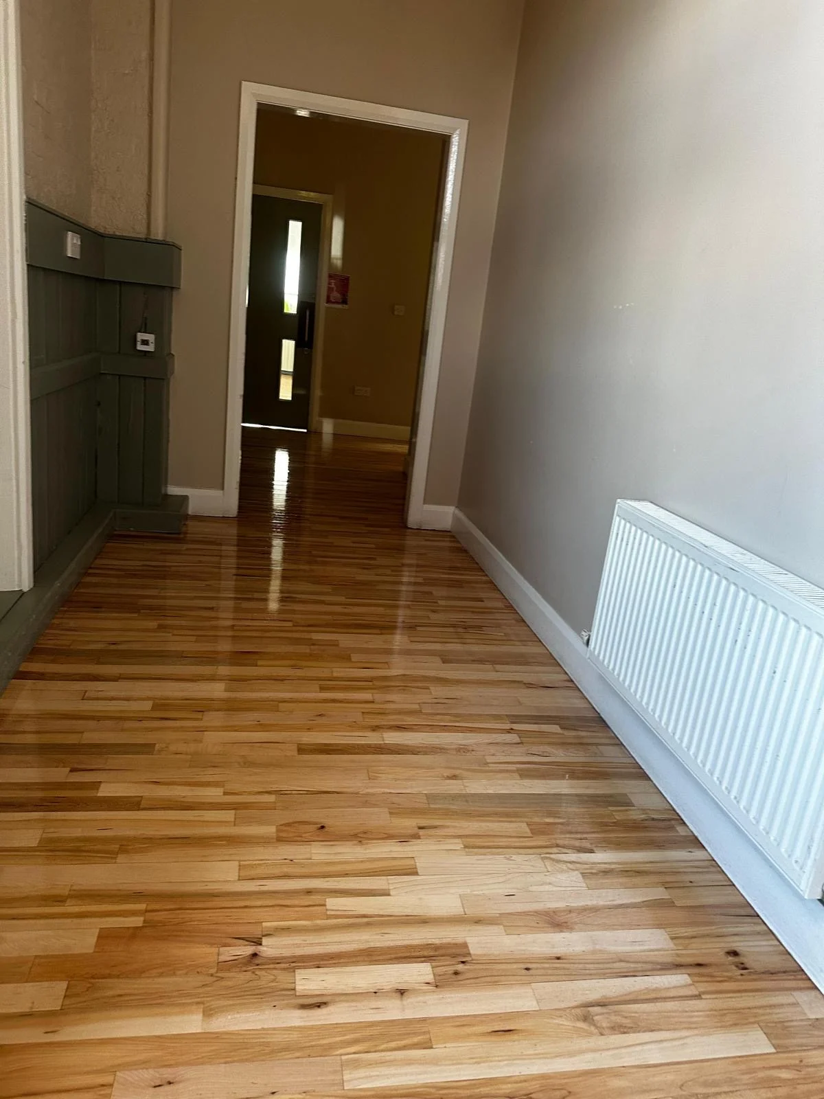 A semi-solid wooden floor sanded & stained with a nice coat.