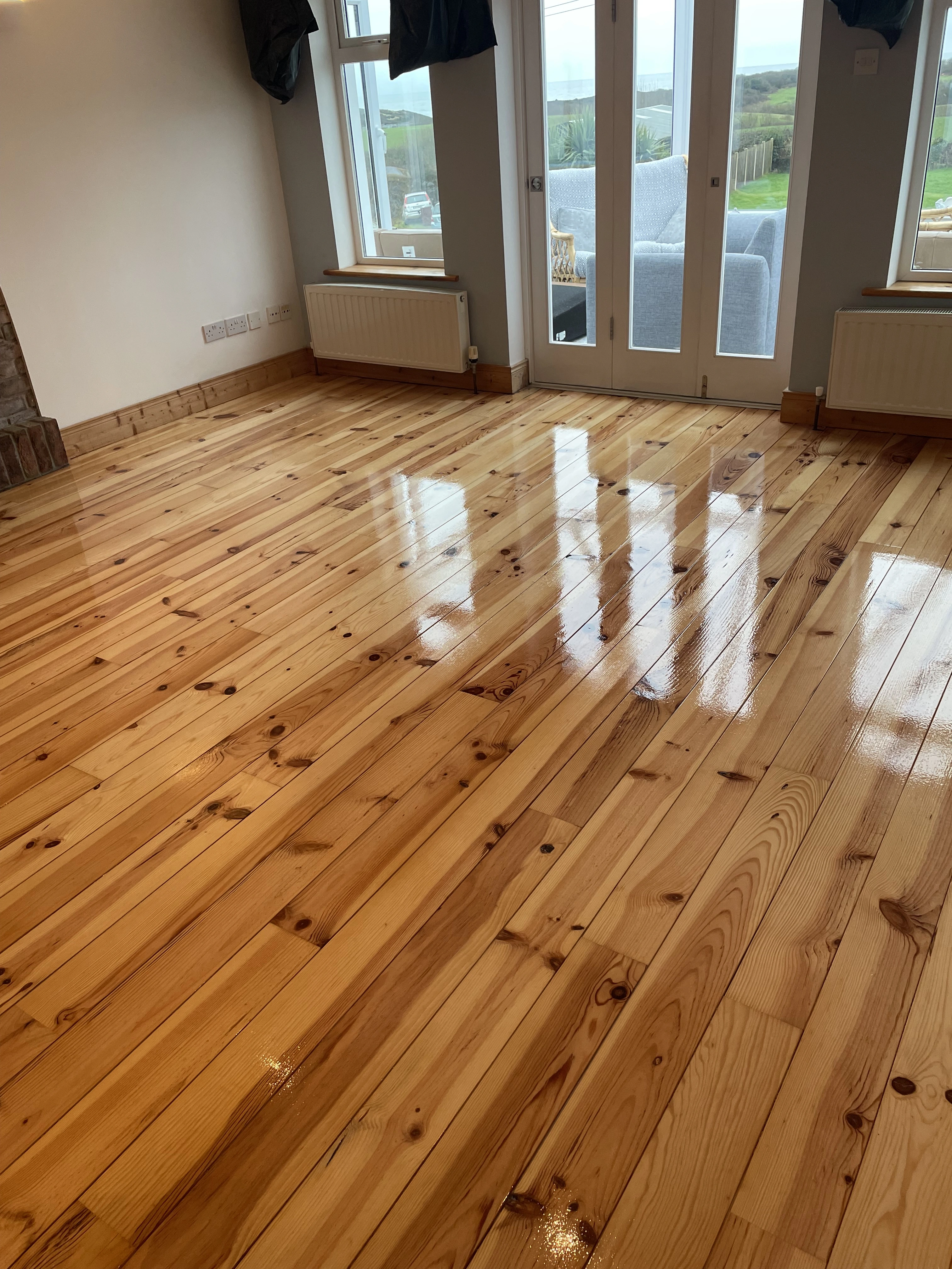 A room from a house with semi-solid wooden floor sanded & stained.