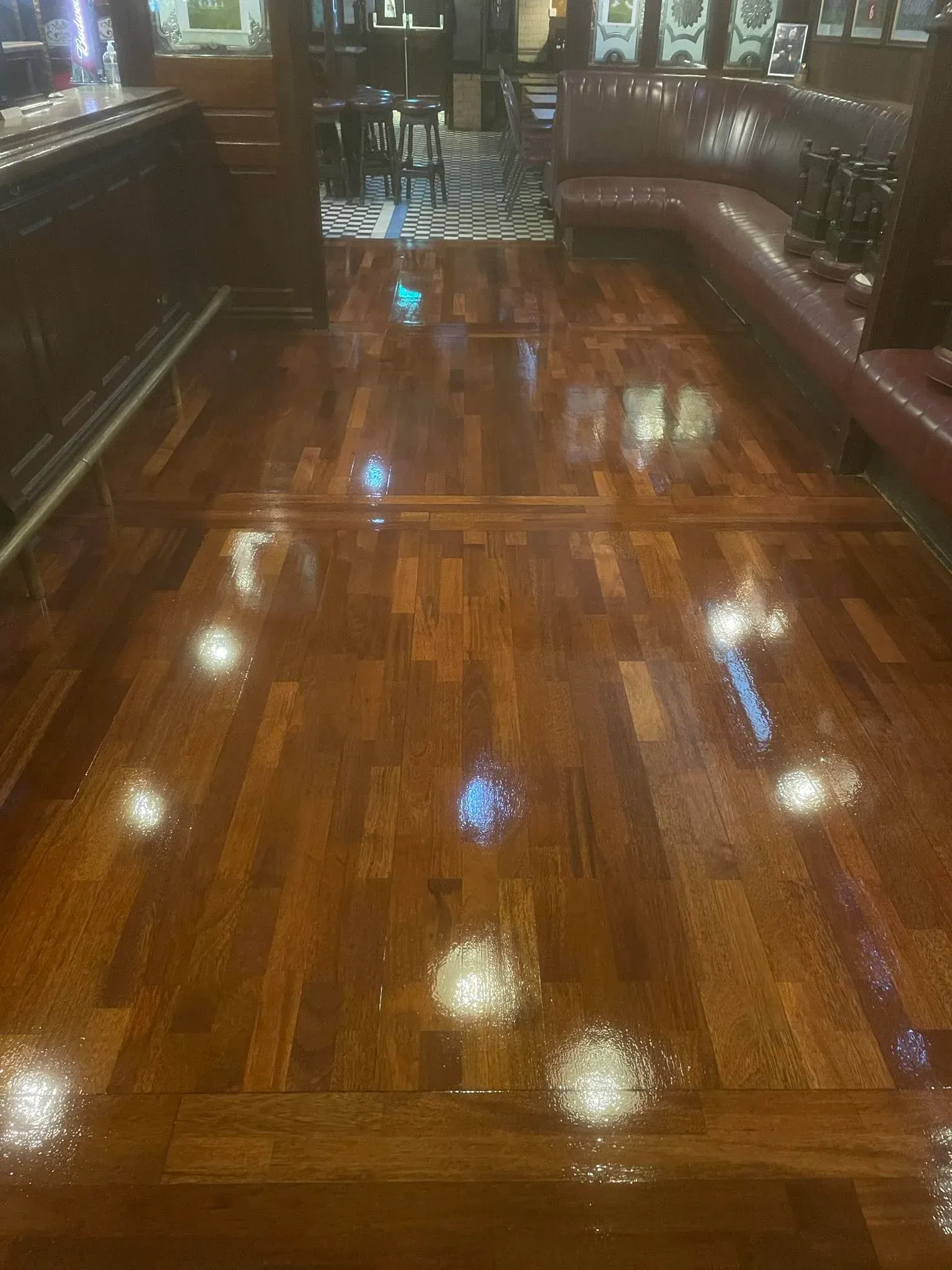 Pub entrance, close to sofas, with sanded & stained wooden floor.