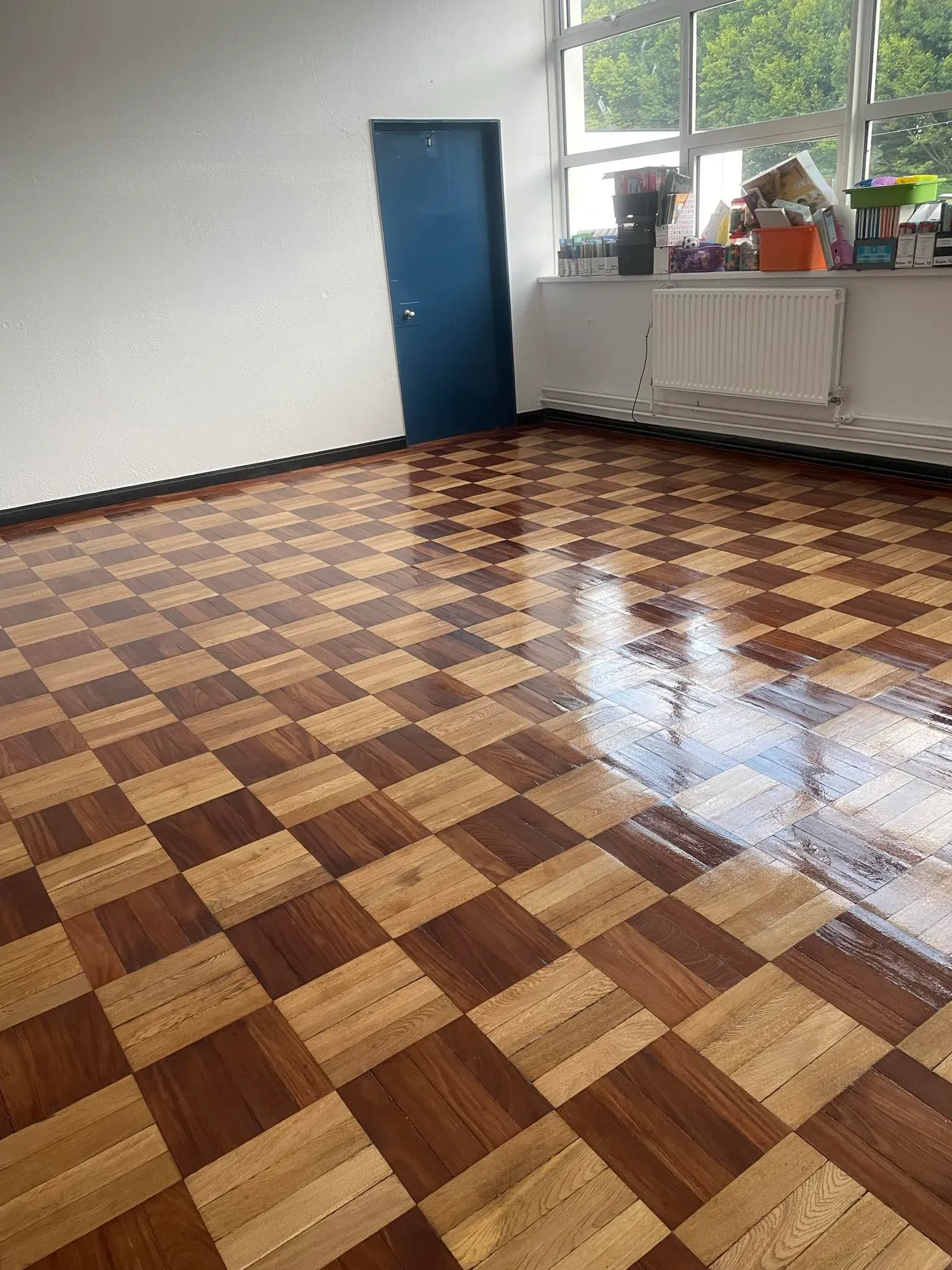 Classroom with a sanded & stained wooden floor.